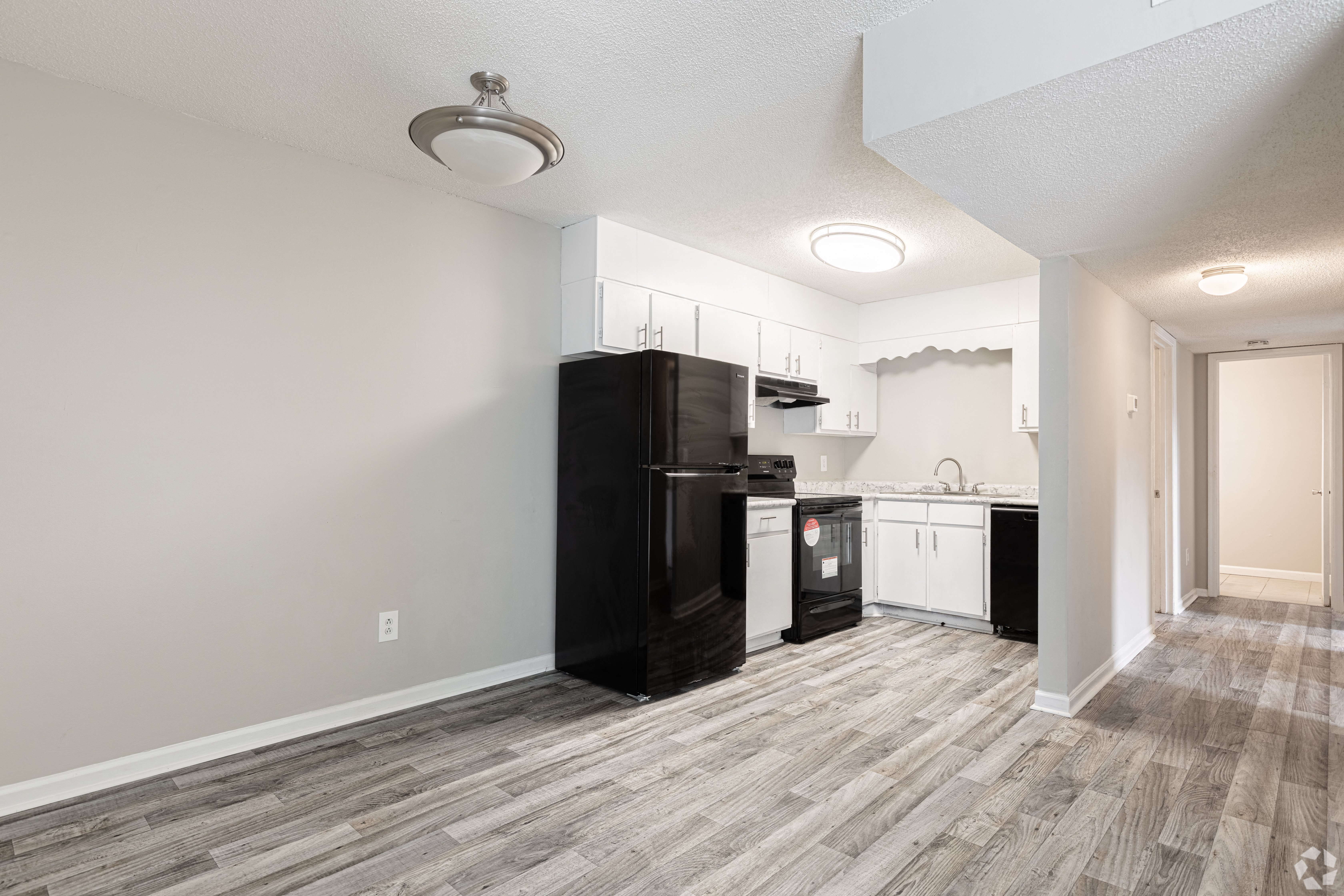 a kitchen with a black refrigerator freezer next to a stove top oven